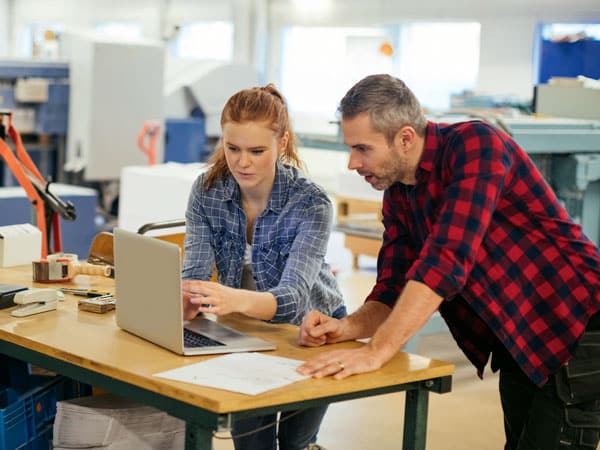 People on a computer managing a print job